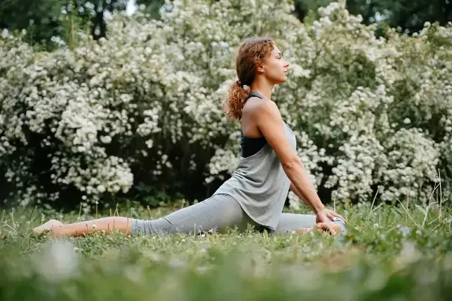 A woman is doing yoga in a field of flowers