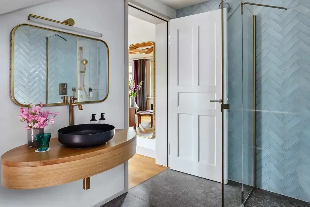 A bathroom with a sink, mirror, and shower