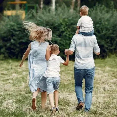 A family walking through a field holding hands