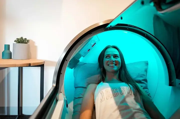 A woman laying in a hyperbaric oxygen therapy chamber